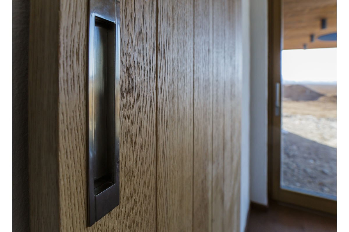 Family house interior - In the bathroom, we built a basin cabinet sprayed with a powder colour, and storage space, visible in the mirror’s reflection. There was even enough space for a built-in washing machine and dryer.