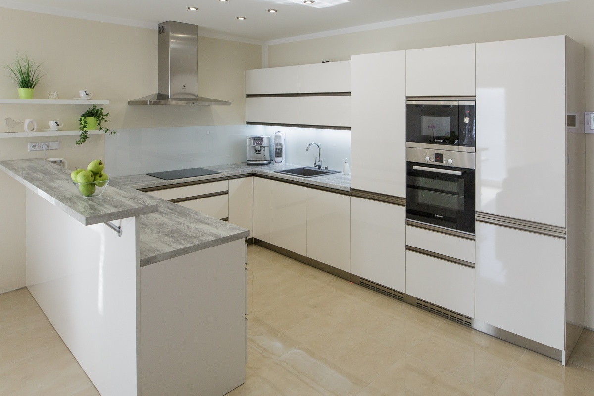 Kitchen - The kitchen is high-gloss and equipped with the highest-quality Blum ironwork. Traditional handles were replaced with strip handles. The facing behind the worktop is made from the lacomat glass.