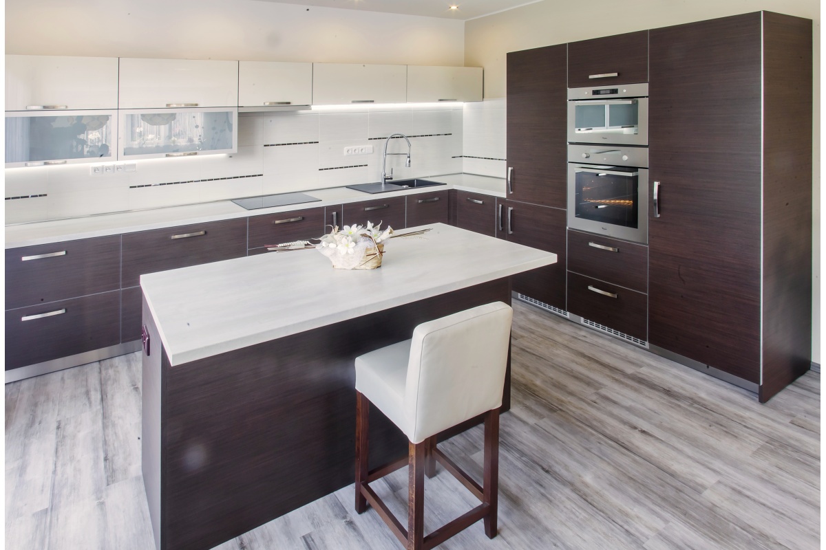 Two-generation house - The kitchen has a spacious island and dark doors with a stainless edge which matches the appliances, plinth, and handles. 