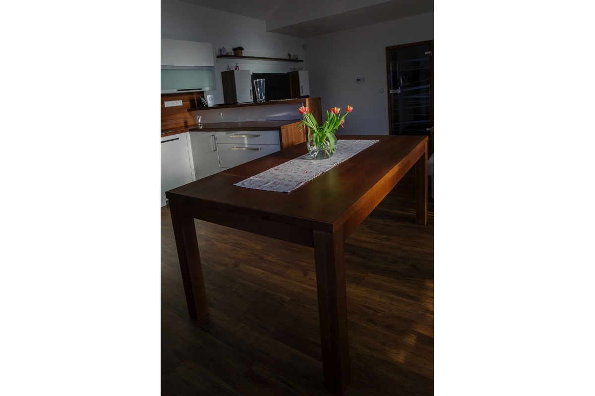 Rodinný dům  - V obývacím pokoji jsou zvoleny stejné materiály jako na kuchyni – bílý vysoký lesk a lamino ořech.	