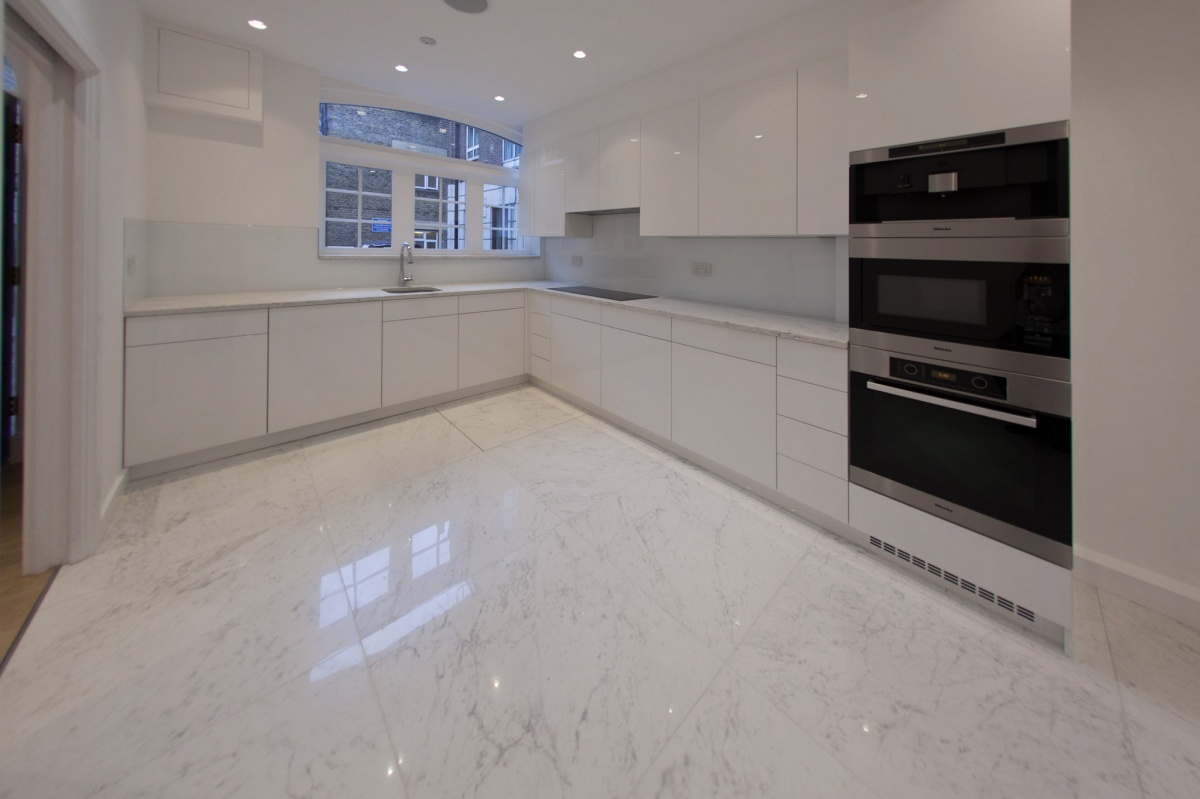 Multi-storey apartment - house in Mayfair - The high-gloss, white-painted kitchen with a marble worktop matching the floor in the same design has additional feature of the best quality electrical door opener of Blum Brand. https://www.blum.com/en/en/01/60/20/